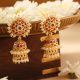 Gold jhumkas with pearls and pink stone accents